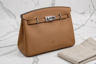 Sac Hermès Birkin 30 en cuir togo Étuve posé sur marbre blanc, vue 3/4 avec surpiqûres sellier et quincaillerie palladium visibles
